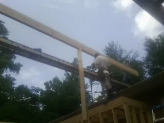 Carpenter setting a ridge beam over a new addition frame — Ice Dam Removal by Roofing Brothers in Rock Springs