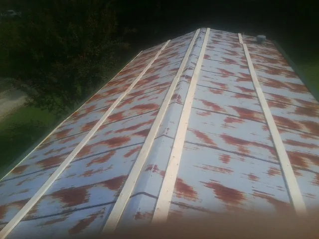 Rusted metal roof panels with new wood purlins before replacement — Storm Damage Roof Repair in Rock Springs by Roofing Brothers