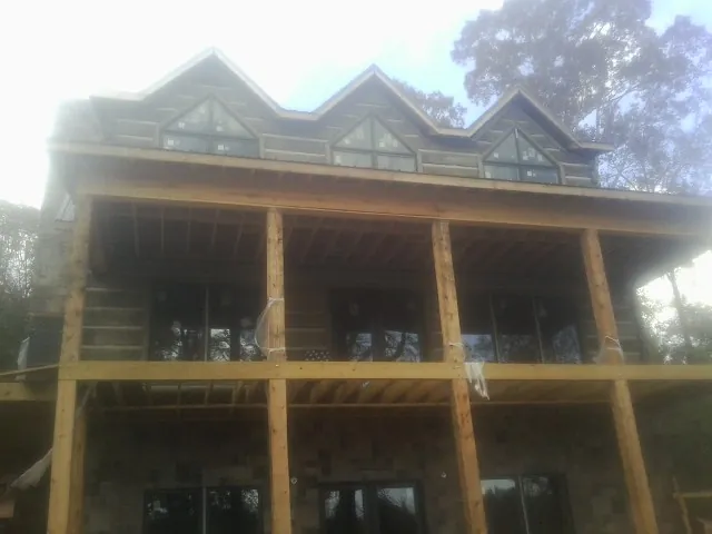 Dormers and porch framing on a large log home under construction — Roof Coating work by our crew in Rock Springs