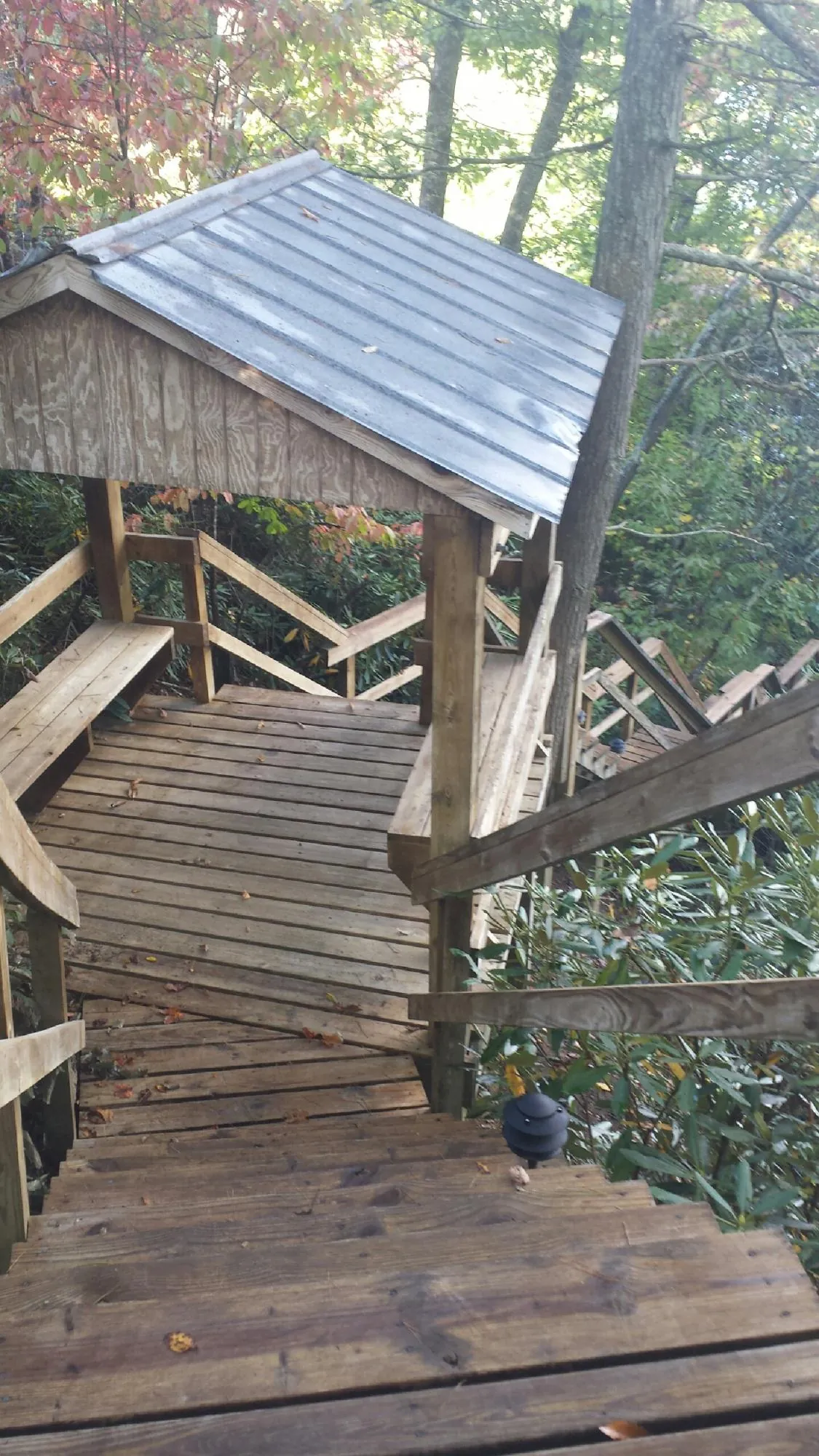 Metal roofed shelter over wooden steps on a wooded walkway — Skylight Repair & Installation work by our crew in Rock Springs
