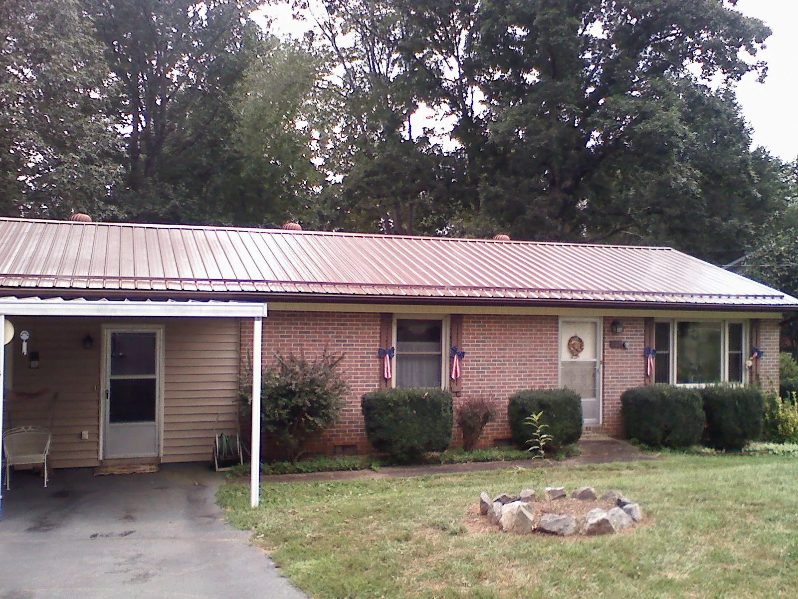 Bronze metal roof and carport on a brick ranch home — Roof Repair work by our crew in Rock Springs