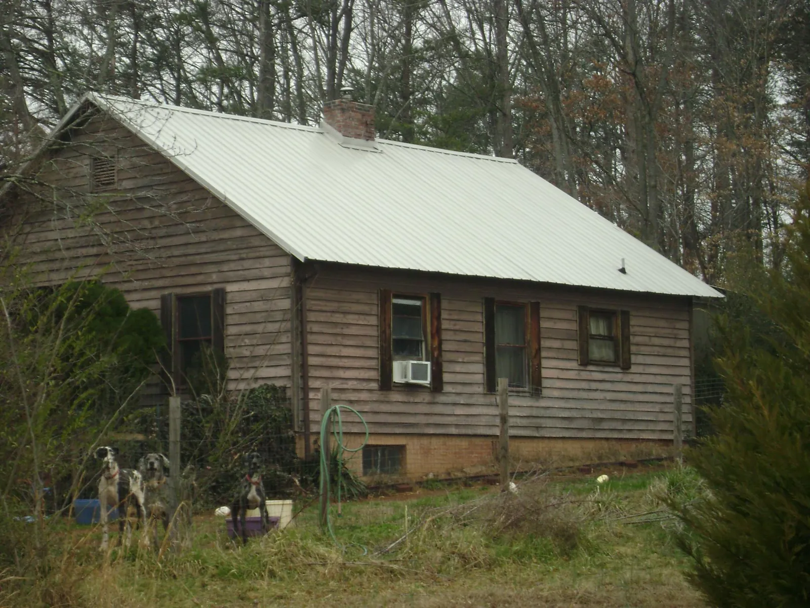 White metal roof on an old wood sided farmhouse, from a Metal Roof Installation job in Rock Springs